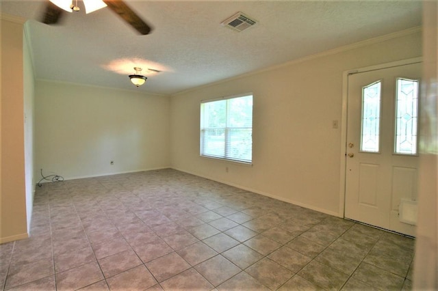 tiled foyer entrance with a textured ceiling, ceiling fan, and ornamental molding