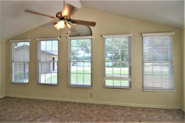 empty room featuring a textured ceiling, vaulted ceiling, and ceiling fan