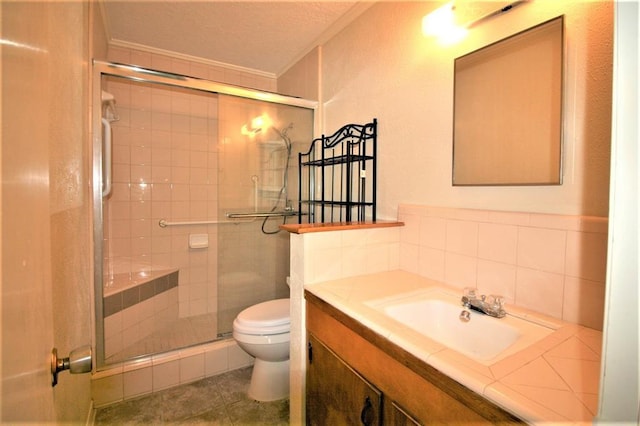 bathroom featuring vanity, toilet, a shower with shower door, and crown molding