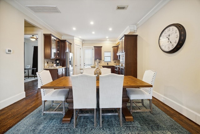 dining area with crown molding, ceiling fan, and dark wood-type flooring