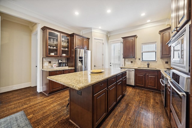 kitchen with sink, a center island, dark brown cabinets, and appliances with stainless steel finishes