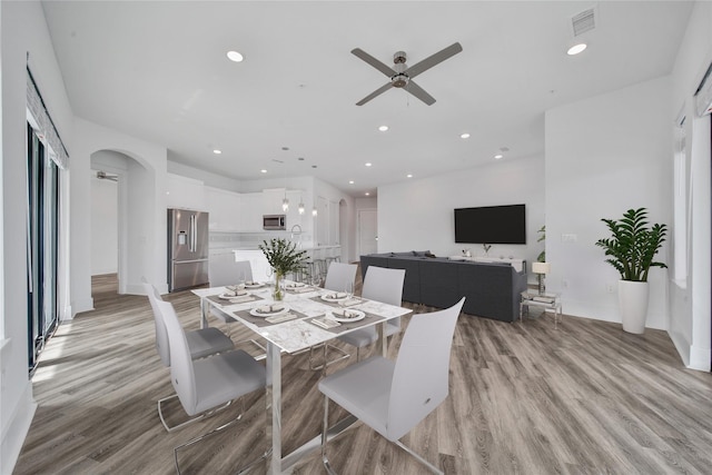 dining area with light wood-type flooring and ceiling fan