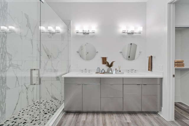 bathroom featuring hardwood / wood-style flooring, vanity, and a shower with door