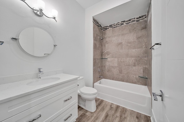 full bathroom with vanity, hardwood / wood-style floors, tiled shower / bath combo, and toilet