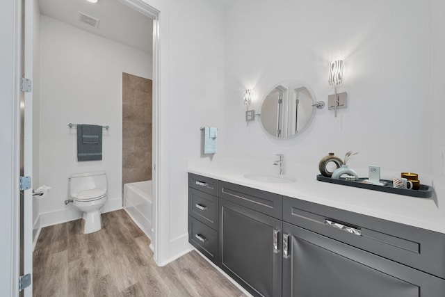 full bathroom with toilet, vanity, tiled shower / bath combo, and hardwood / wood-style flooring