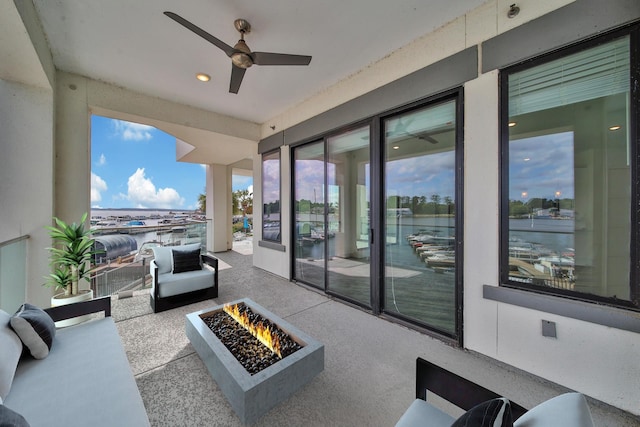 view of patio featuring ceiling fan and an outdoor living space with a fire pit