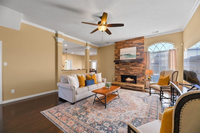 living room with decorative columns, ceiling fan, dark hardwood / wood-style floors, and ornamental molding