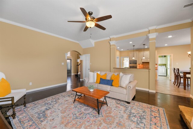 living room with ceiling fan, ornamental molding, ornate columns, dark hardwood / wood-style flooring, and washer / dryer