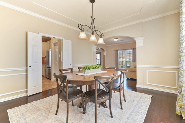 dining room featuring decorative columns, an inviting chandelier, dark hardwood / wood-style floors, and crown molding