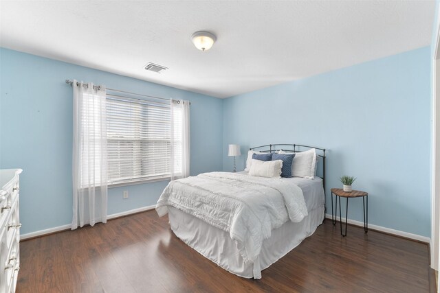 bedroom with dark hardwood / wood-style flooring