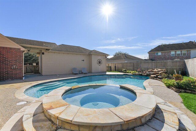 view of pool with an in ground hot tub