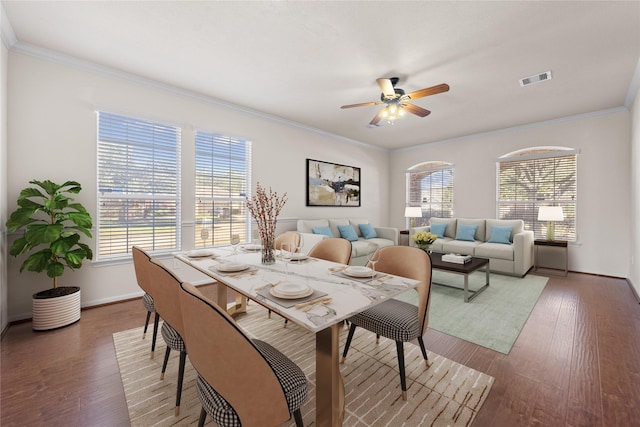 dining space with ceiling fan, dark hardwood / wood-style floors, and crown molding