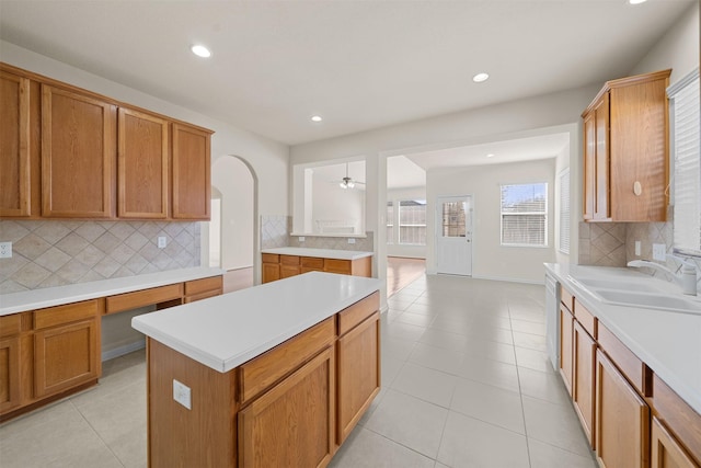 kitchen featuring tasteful backsplash, light tile patterned floors, sink, and a center island