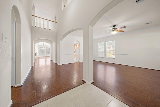 interior space featuring ceiling fan, ornamental molding, and a high ceiling