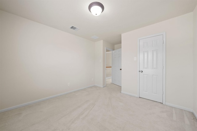 unfurnished bedroom with a closet and light colored carpet