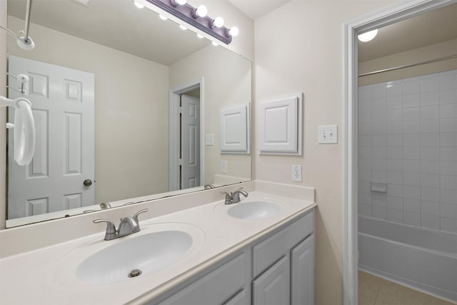 bathroom with tiled shower / bath combo, vanity, and tile patterned flooring