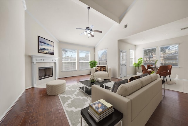 living room with ceiling fan, dark wood-type flooring, a wealth of natural light, and a fireplace