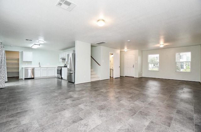 unfurnished living room featuring sink