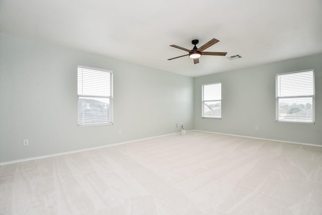 carpeted spare room with ceiling fan