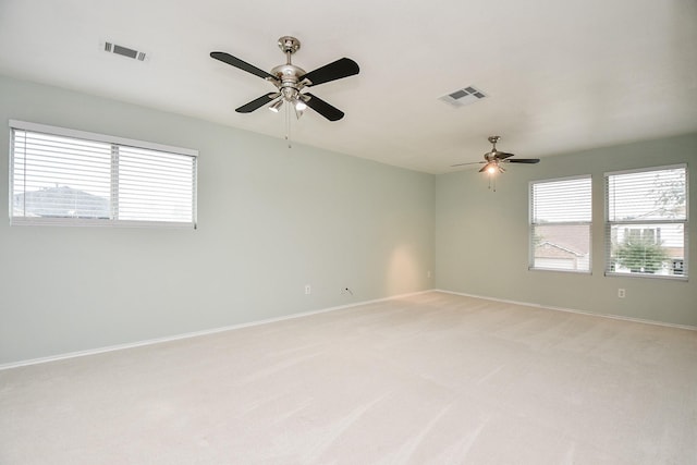 carpeted empty room with ceiling fan and a healthy amount of sunlight