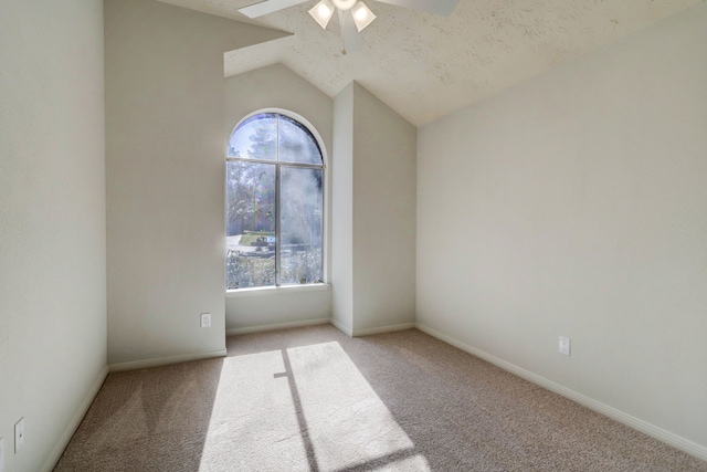 empty room featuring ceiling fan, light colored carpet, lofted ceiling, and a textured ceiling