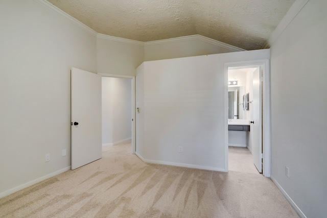 carpeted empty room featuring a textured ceiling, lofted ceiling, and ornamental molding