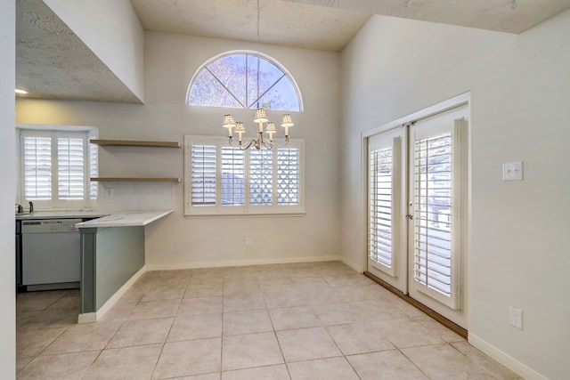 unfurnished dining area with an inviting chandelier and light tile patterned flooring