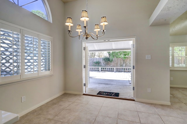 entryway featuring light tile patterned floors and a notable chandelier