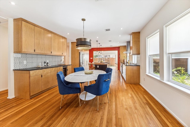 dining area featuring a wealth of natural light, sink, and light hardwood / wood-style floors