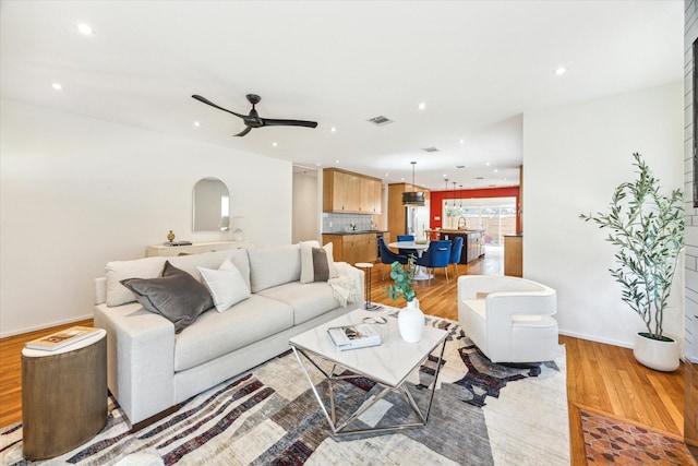 living room featuring ceiling fan and wood-type flooring