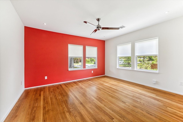 unfurnished room with ceiling fan, plenty of natural light, and light wood-type flooring