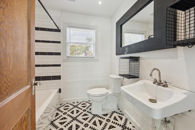 full bathroom featuring tile patterned floors, toilet, tiled shower / bath, and sink