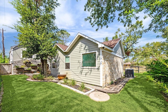 rear view of property with a lawn and central AC