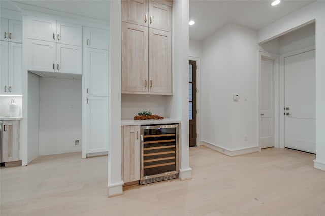 bar featuring white cabinets, light hardwood / wood-style floors, and beverage cooler