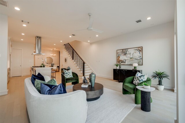 living room featuring ceiling fan and light hardwood / wood-style flooring