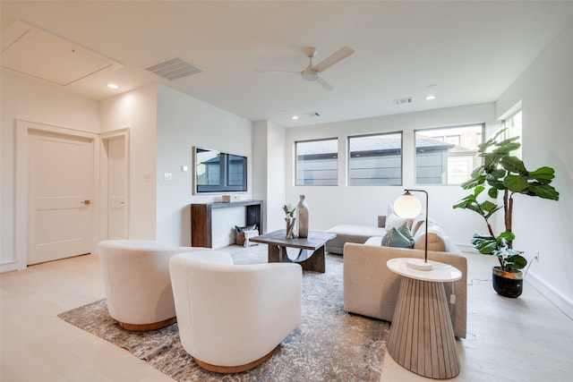 living room featuring ceiling fan and light hardwood / wood-style flooring