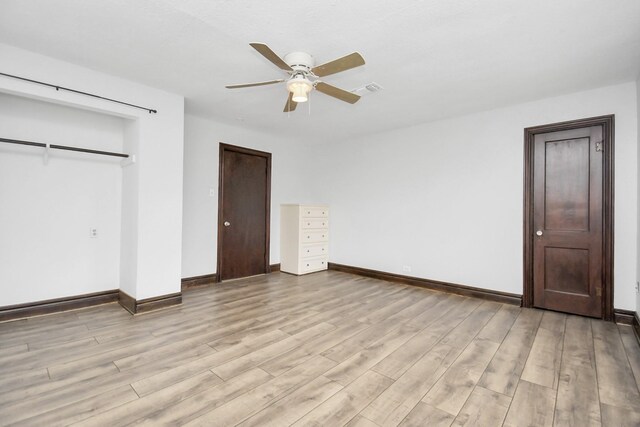 unfurnished bedroom with a closet, light hardwood / wood-style floors, and ceiling fan