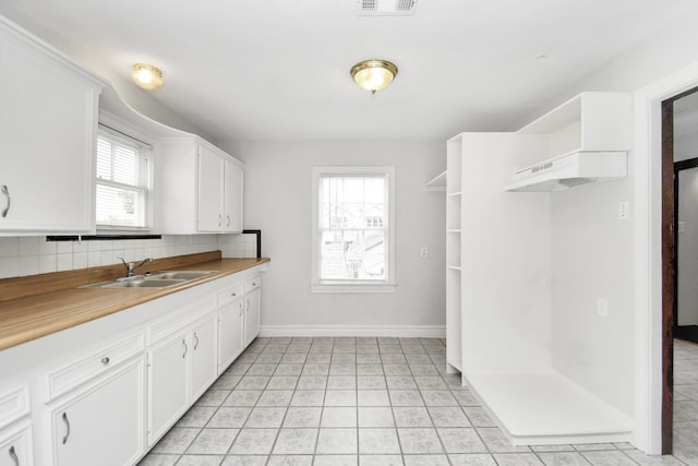 kitchen featuring white cabinets, backsplash, plenty of natural light, and sink