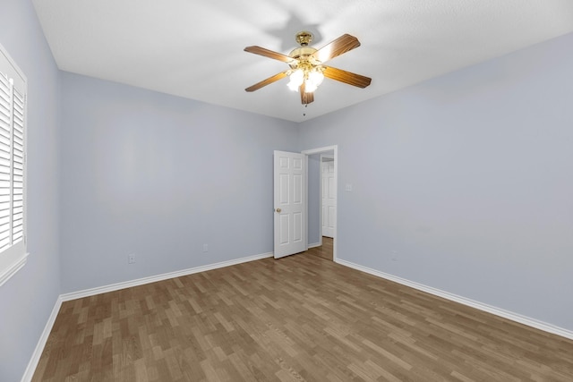 spare room featuring ceiling fan, hardwood / wood-style floors, and plenty of natural light