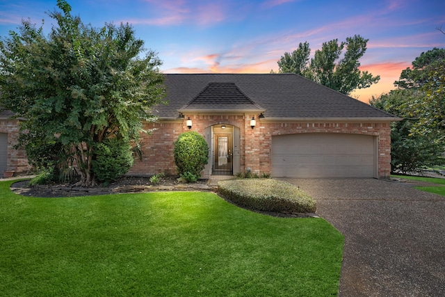 view of front of house with a garage and a lawn