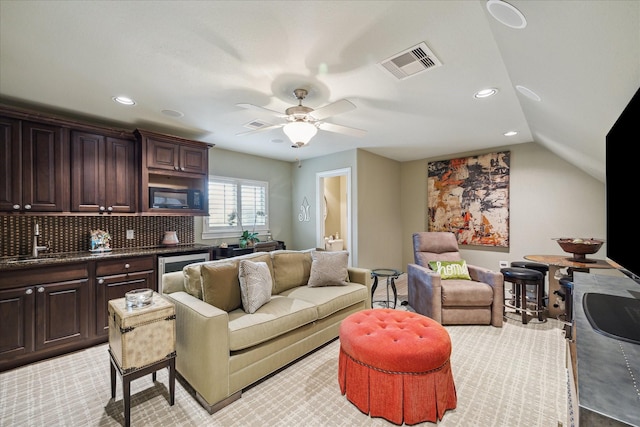 carpeted living room with lofted ceiling, sink, and ceiling fan