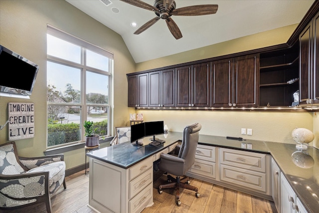 office with light hardwood / wood-style flooring, built in desk, vaulted ceiling, and ceiling fan