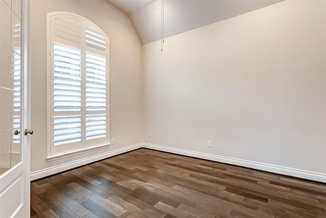 spare room with dark hardwood / wood-style floors and vaulted ceiling