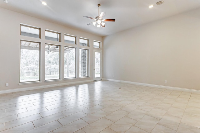 spare room with ceiling fan, light tile patterned flooring, and a wealth of natural light