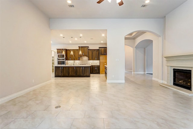 tiled living room with ceiling fan and sink