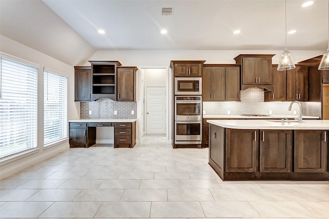 kitchen with dark brown cabinetry, sink, a healthy amount of sunlight, pendant lighting, and appliances with stainless steel finishes