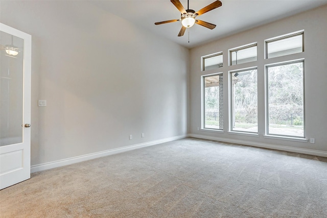 spare room with ceiling fan and light carpet