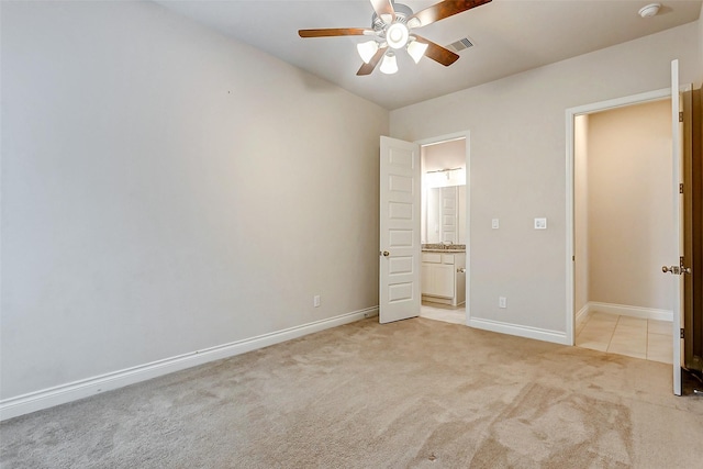 unfurnished bedroom featuring connected bathroom, ceiling fan, and light colored carpet