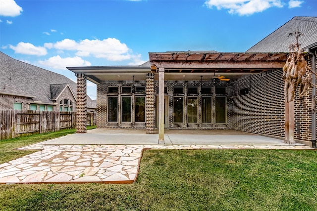 back of property featuring a lawn, a patio area, and ceiling fan