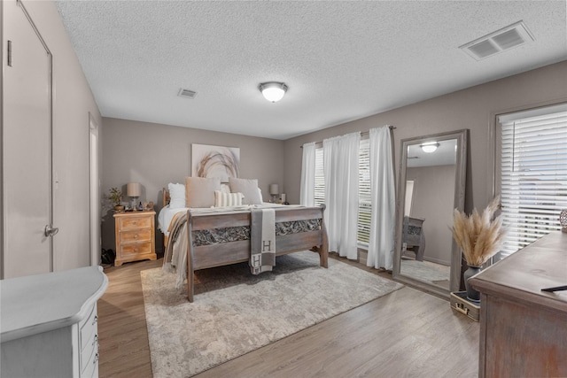 bedroom featuring a textured ceiling and light wood-type flooring